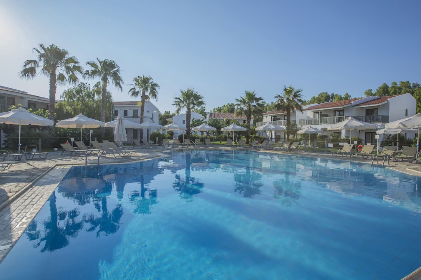 Golden Coast Resort, main pool framed by palm trees and bungalows